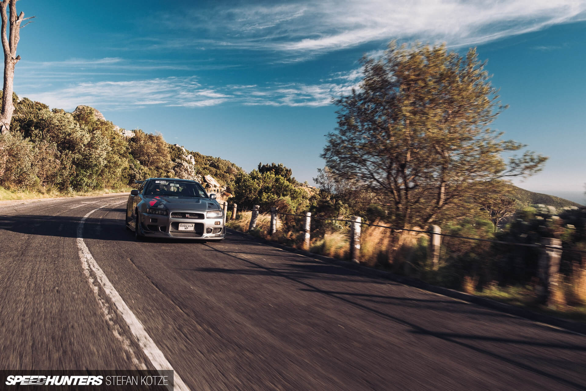 Nissan Skyline R34 GT-R  on a mountain road in 
                    a sky landscape