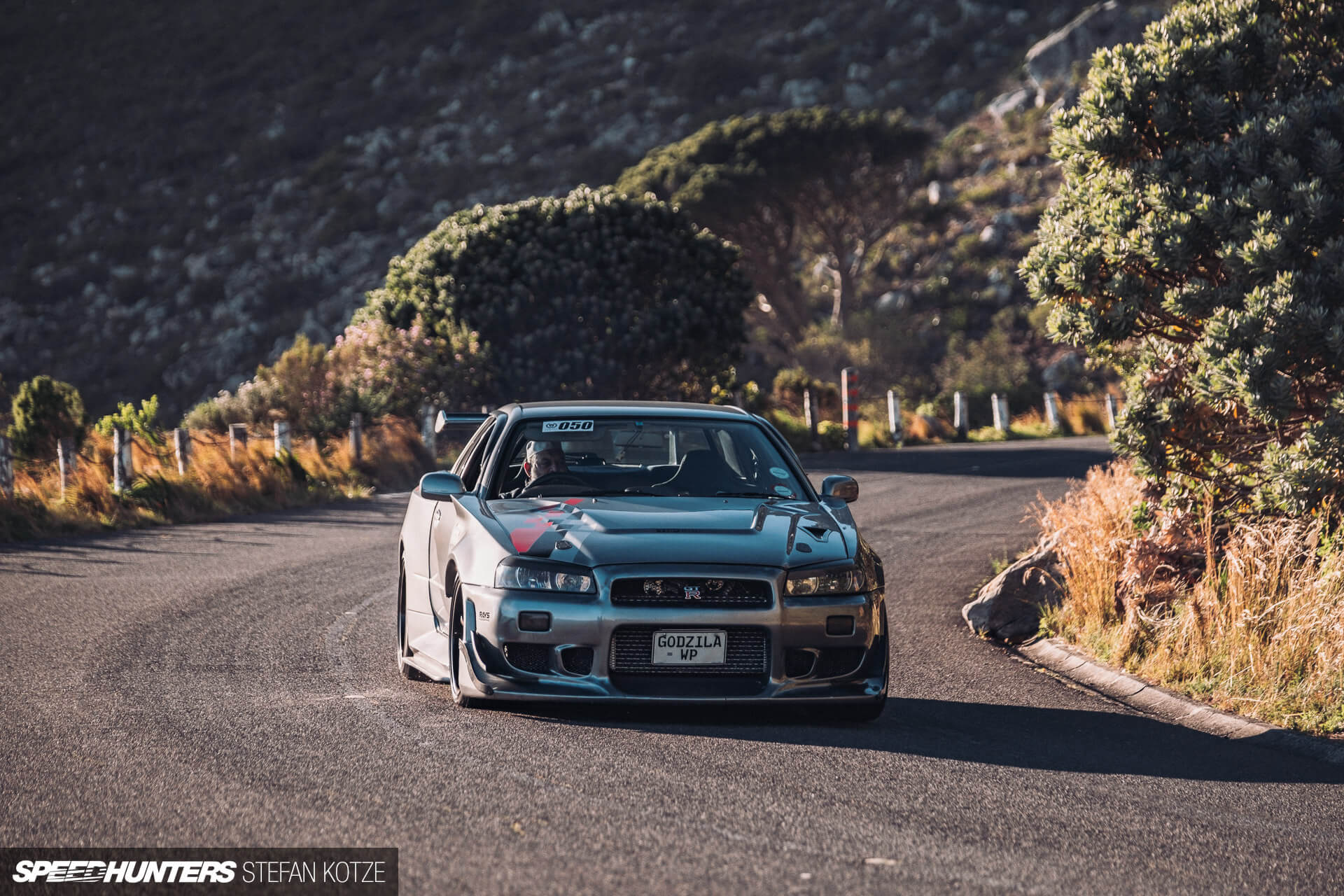 Front view of the Nissan Skyline R34 GT-R on a 
                    mountain road