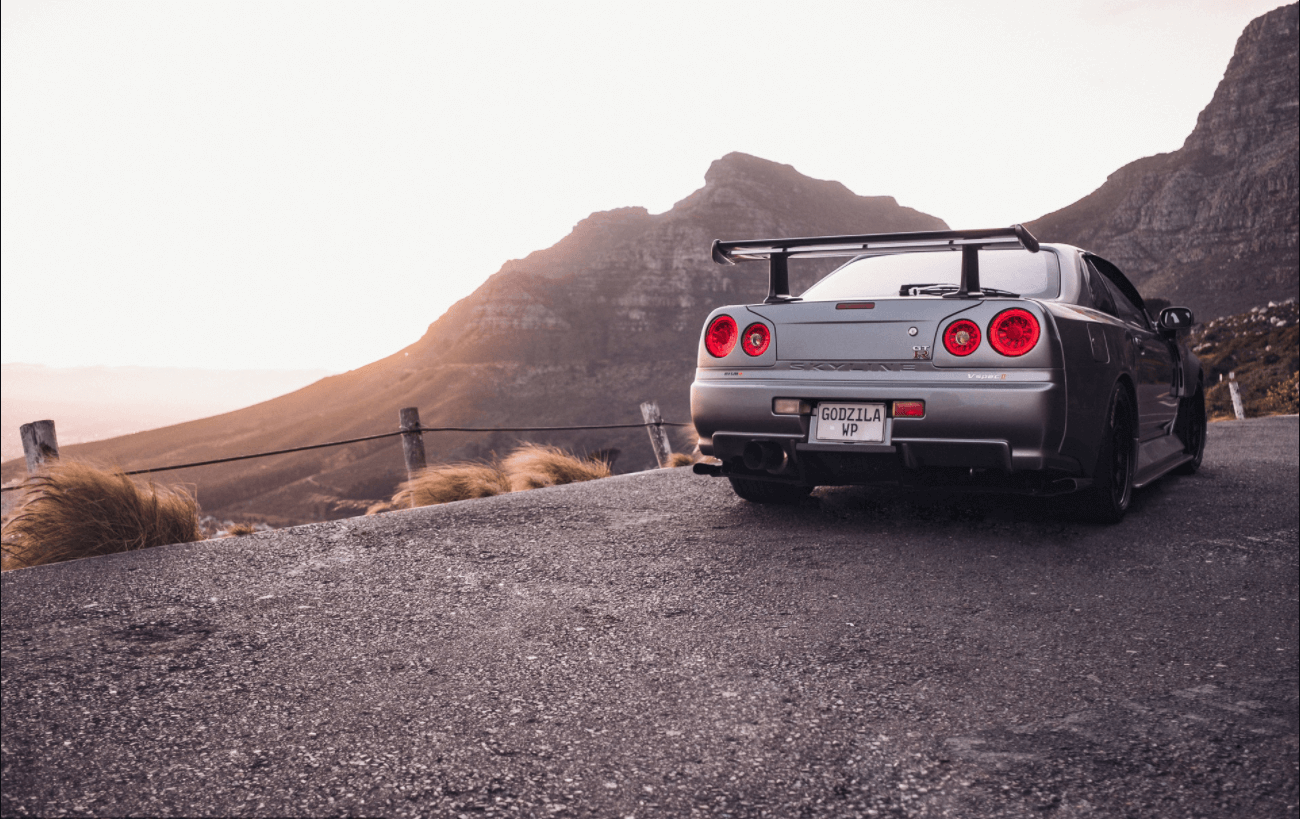 Nissan Skyline R34 GT-R seen from the 
                    rear in a mountain background