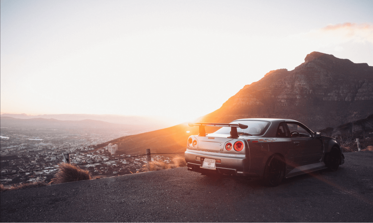 Nissan Skyline R34 GT-R with a 
                    mountain as background